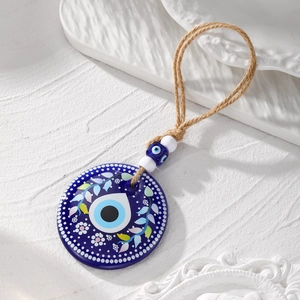 Detailed view of large Evil Eye acrylic pendant with floral prints and natural hemp rope