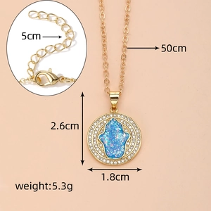 Detailansicht der vergoldeten Hamsa-Halskette mit funkelndem blauen Opal-Anhänger
