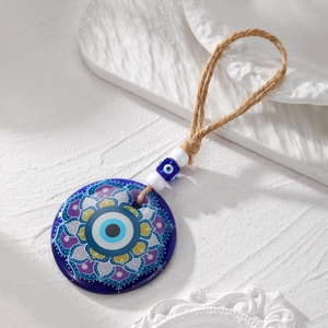 Macro view of blue Evil Eye acrylic pendant with mandala pattern and hemp rope detailing