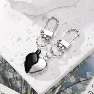 Set di portachiavi alla moda in lega nera e argento per coppie su sfondo bianco