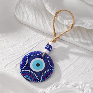 Detailed view of hand-painted evil eye acrylic pendant with vibrant tribal patterns