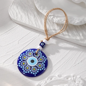 Macro detail of acrylic Evil Eye wall hanging with tribal mandala art and hemp rope