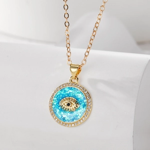 Nahaufnahme des goldenen Evil Eye Anhängers mit blauem Glitzern und Zirkonia