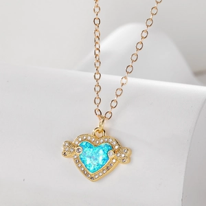 Elegante goldene Herz-Opal-Halskette mit Kristall-Engelsflügeln auf weißem Sockel