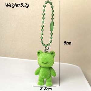 Détail d'un pendentif grenouille floqué vert mesurant 8cm de hauteur et 2,2cm de largeur