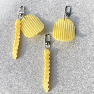 Macro detail of realistic wavy potato chip and french fry silicone keychain charms