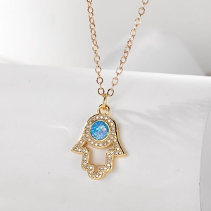 Goldene Hand der Fatima Halskette mit blauem Opal und weißen Zirkonia auf weißem Sockel
