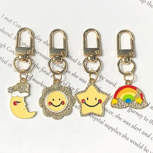 Detailed close-up of alloy star, moon, and rainbow charms with rhinestones and lobster clasp
