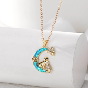 Detailansicht goldener Mondsichel-Anhänger mit Katzen- und Hundesilhouette in blauem Opal