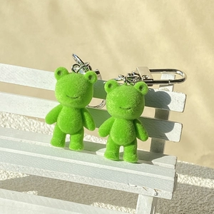 Pendentifs ours floqués verts mignons avec porte-clés argentés sur un petit banc