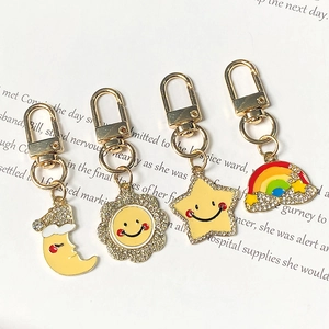 Set of four cute alloy keychains with star, moon, rainbow, and sun pendants and rhinestones