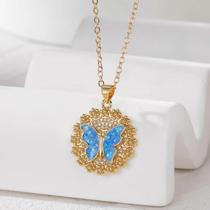 Macro shot of 18k gold plated butterfly pendant necklace with sparkling blue opal stone