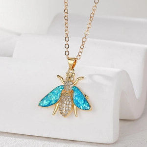 Detail of a gold bee pendant necklace with blue opal wings and sparkling zircon pavé