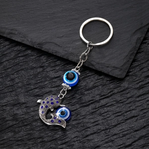 Dettaglio del ciondolo a delfino in argento con strass blu e perline contro il malocchio