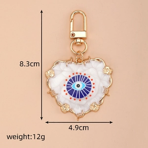 Detail view showing evil eye heart keychain dimensions 8.3x4.9cm with gold rose accents