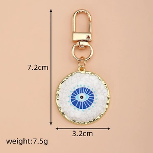 Evil eye heart keychain with blue enamel detail and gold-tone finish showing 7.2cm dimensions