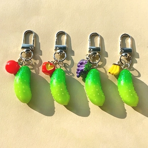 Detailed view of resin cucumber keychains with cherry, apple, grape, and banana charms