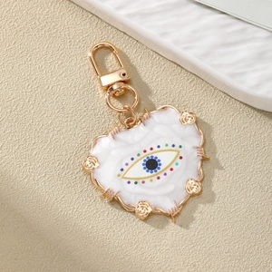 Detailed macro view of heart-shaped evil eye keychain with gold roses and lobster clasp