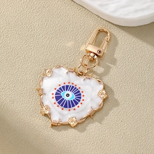 Ethnic style heart evil eye keychain in gold alloy with blue resin eye and floral details