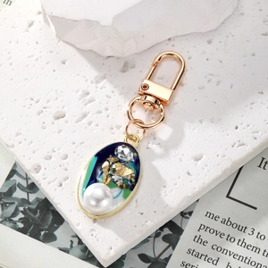 Vintage gold keychain with blue resin oval pendant, white pearl and crystal accents