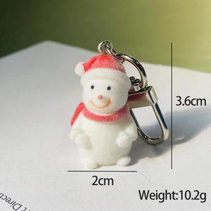 Close-up of white flocked Christmas snowman keychain with red hat and silver metal clasp