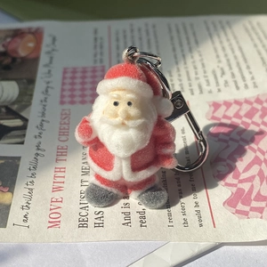 Cute flocked Santa Claus keychain charm with silver metal buckle on magazine