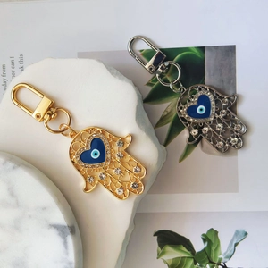Hamsa Hand keychain in gold and silver with blue heart evil eye and clear crystals