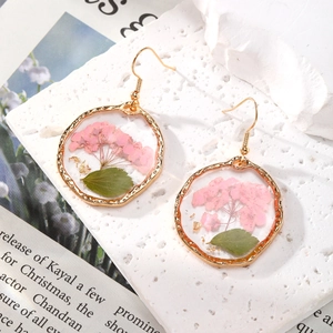 Orecchini con fiori secchi rosa in resina dorata su base di marmo bianco