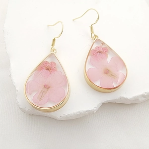 Exquisite Tropfenohrringe mit echten rosa Trockenblumen in Harz und Goldfassung