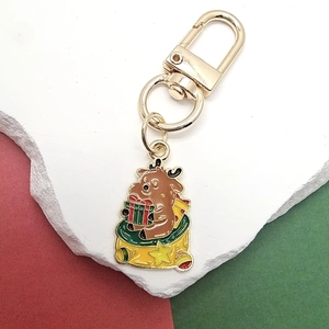 Detail eines Weihnachts-Rentier-Schlüsselanhängers mit festlichem Geschenksack und Karabiner