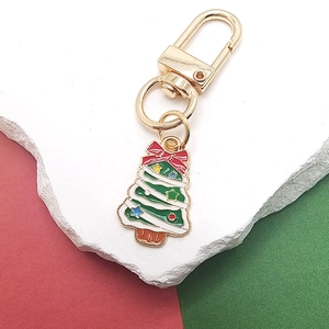 Detail eines Weihnachtsbaum-Emaille-Anhängers mit goldenem Karabinerverschluss auf Marmor