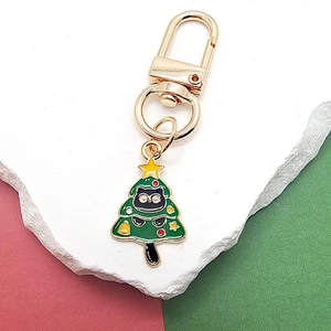 Detailaufnahme eines Weihnachtsbaum-Schwarze Katze Emaille-Schlüsselanhängers in Gold