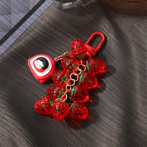 Close-up of vibrant red translucent resin strawberry charms with a cute cartoon girl pendant