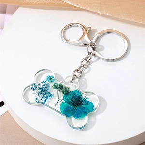Porte-clés os de chien en acrylique avec fleurs séchées bleues et fermoir argenté
