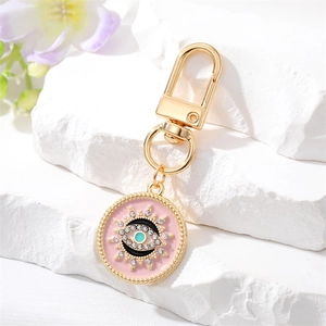 Porte-clés bohème doré avec œil en émail rose et décoration de strass scintillants