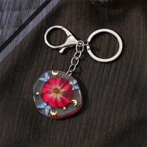 Handmade clear resin keychain with red dried flower and gold moon star charms