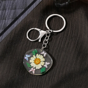 Creative resin keychain featuring real white daisy flowers and purple butterfly charm