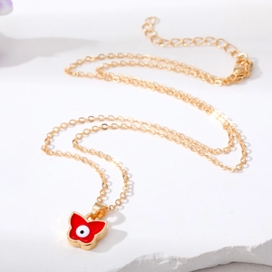Elegante goldene Schmetterlingskette mit rotem Teufelsauge Anhänger auf Marmor