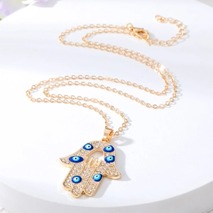 Golden Hamsa Hand necklace with evil eye pendants and sparkling crystal accents