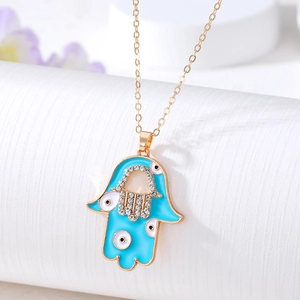 Golden Hamsa hand necklace with blue enamel evil eye and sparkling rhinestones