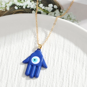 Blue Hamsa Evil Eye pendant necklace on gold chain with white floral accents