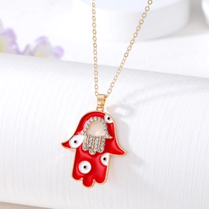 Detailed close-up of a Hamsa hand pendant with red enamel, evil eye, and clear rhinestones
