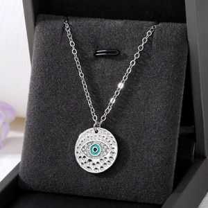 Macro shot of silver evil eye pendant with sparkling crystals in a black jewelry box