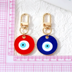 Blue and red Evil Eye enamel pendants with golden keychains, size shown with ruler