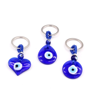 Blue glass Evil Eye keychain set with heart and teardrop pendants on white background