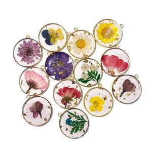 Handmade botanical resin pendants with dried flowers and gold foil in gold frames