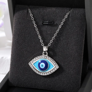 Detailed close-up of retro evil eye square pendant with blue enamel and rhinestones