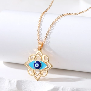Detailed close-up of golden evil eye pendant with intricate floral hollow pattern and blue eye