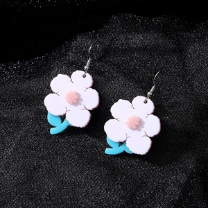 Boucles d'oreilles fleurs roses en acrylique avec feuilles bleues sur fond noir texturé