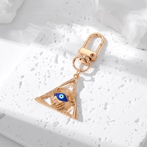 Vintage golden Hamsa palm keychain featuring a triangular blue evil eye oil drop pendant